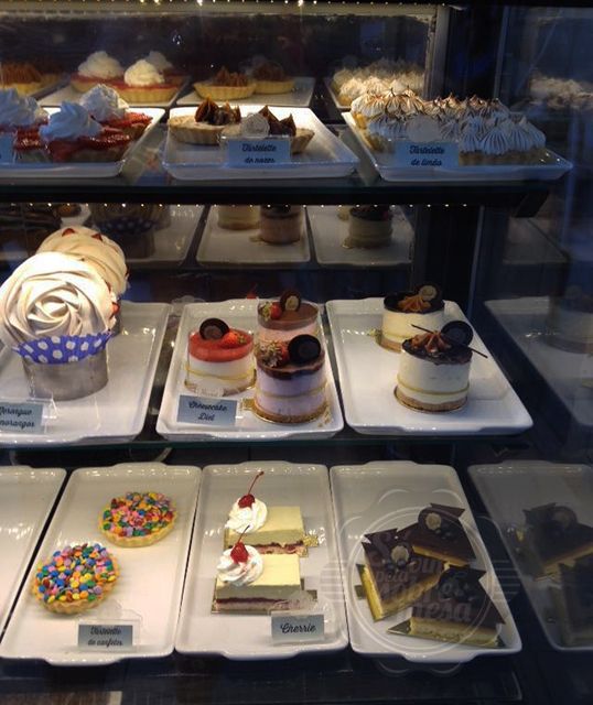 [Doçuras francesas com um 'q' de brasilidade. Vitrine alegre colorida e repleta de amor em forma de doces e sobremesas]