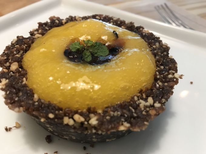 \[Seguindo a filosofia da alimentação viva, a Tortinha Raw do Puro mescla a doçura das tâmaras e manga com o azedinho do maracujá\]