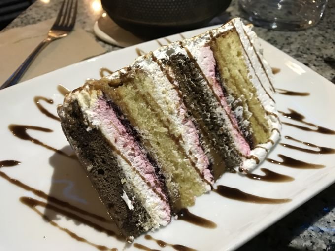 A que parece fugir das características principais de uma Tres Leches, mas em sua receita a C\`est si Bon agregou massa de chocolate e geleia de framboesa. E posso contar? Ficou maravilhosa. Mas, um alerta: a fatia é enorme, o bolo além de alto tem um diâmetro gigante. Então, aconselho dividir para não desperdiçar: a não ser que, você seja uma formiga-leão.